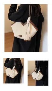 Detail of the white pleated tote bag with brown leather trim and stylish logo tag