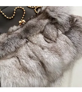 Gros plan sur la texture en fausse fourrure du sac avec chaîne en métal doré
