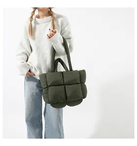 Detail shot of puffy quilted dark green tote bag featuring luxury padded texture