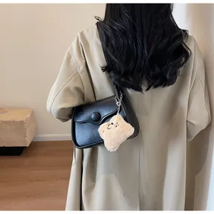 Detailed view of black PU leather shoulder bag with round buckle and plush toast charm