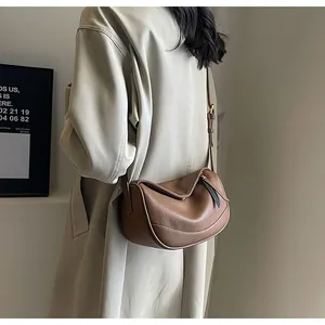 Detailed view of brown lindy bag with litchi grain leather and gold metal hardware