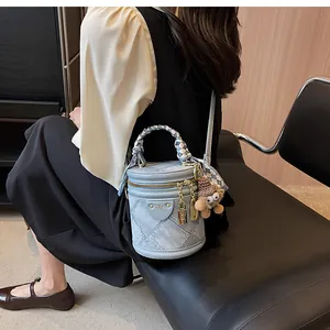 Blue denim cylinder bucket bag with silk scarf handle and cute bear charm detail