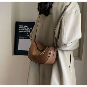 Close-up of brown litchi pattern leather texture and curved zipper design on the bag