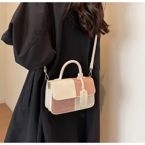 Detalle de bolso de cuero en contraste con costuras de cuatro rejillas y etiqueta chic