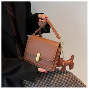 Sac à bandoulière chic en cuir caramel avec boucle dorée et charm chien mignon