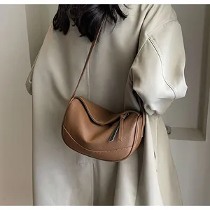 Close-up of the brown lychee pattern leather crossbody bag in a half-moon crescent design