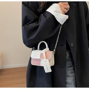 Detailansicht der pink-beigen Minitasche mit Metallkette und modischem Anhänger