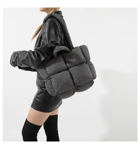 Detailed view of dark gray quilted shoulder bag in down cotton material with wide strap