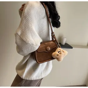 Brown retro crossbody bag with large round buckle and plush star charm on a model