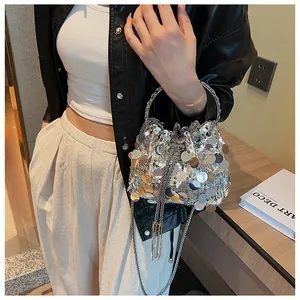 Detail of silver sequin bucket bag featuring metallic fringe and chain drawstring