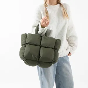Quilted puffer tote bag in olive green with padded handles shown on model outfits