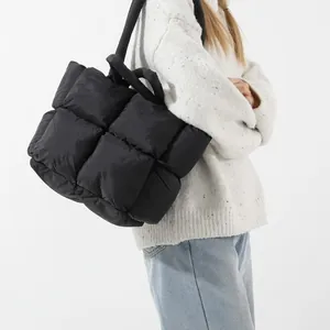 Fashionable black puffer tote bag with quilted padding and soft shoulder strap for women