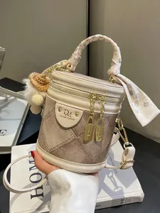 Fashionable denim bucket bag with silk scarf handle and plush pendant accessory