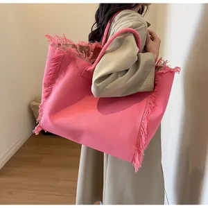 Detailed close-up of pink canvas tote bag featuring stylish fringe edges and round handles