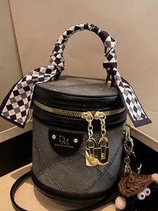 Grey quilted denim bucket bag with silk scarf handle and plush pendant accessory