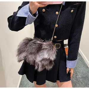 Détail d'un sac bandoulière en fausse fourrure avec chaîne dorée sur tenue chic
