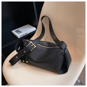 Close-up of black lychee grain leather handbag with gold hardware and smooth zipper detail