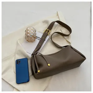 Close-up of dark brown leather pillow bag with gold hardware and drawstring detail