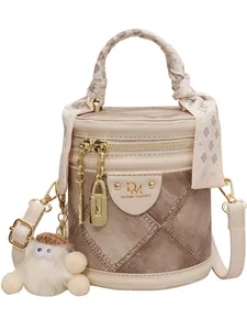 Beige bucket bag with silk scarf handle and plush pendant in a 45-degree studio view