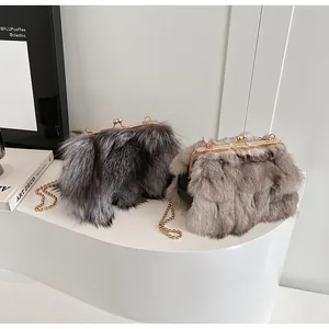 Détail de sacs à bandoulière en fausse fourrure de renard gris et beige avec chaîne dorée
