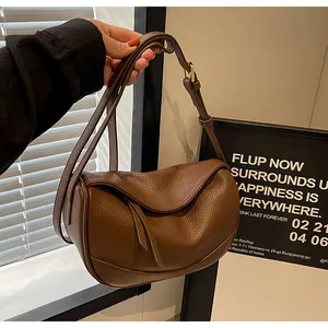 Detailed macro view of brown pebbled leather texture on a crescent moon shaped bag