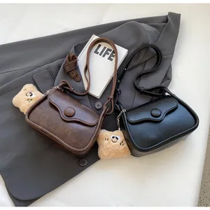 Detail of retro leather crossbody bags in black and brown with star plush charms