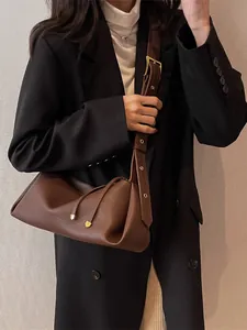 Dark brown leather crossbody pillow bag with adjustable strap and golden hardware