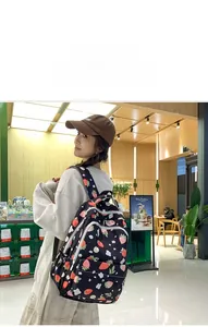 Detail of strawberry print backpack worn by a 165cm model in a cafe setting