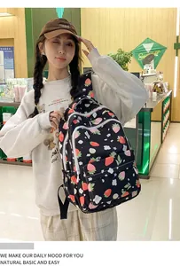 Close-up of strawberry print backpack with durable nylon fabric and white zippers
