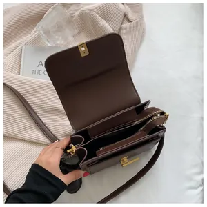 Vue détaillée du sac à bandoulière en cuir marron avec trois compartiments internes