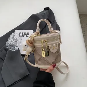 Sac seau en cuir beige et marron avec poignée en soie et pendentif peluche