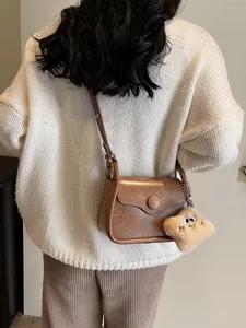 Vintage brown leather crossbody bag for women with a cute star plush charm on shoulder