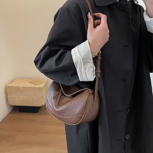 Brown litchi grain leather shoulder bag with adjustable strap and side metal fasteners