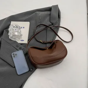 Brown lychee leather crescent hobo bag on grey blazer for casual daily commute