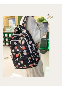 Detail view of the strawberry and flower print pattern on black waterproof nylon backpack