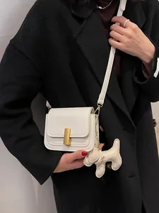 Sac à bandoulière chic en cuir blanc avec boucle dorée et breloque petit chien