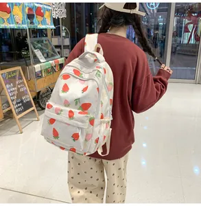 Detail of strawberry print backpack with front zipper pocket in a casual mall setting