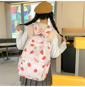 Detail of pink strawberry print backpack showing durable fabric and front zipper pocket