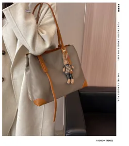 Detail of large patchwork tote bag with rabbit charm against a minimalist interior