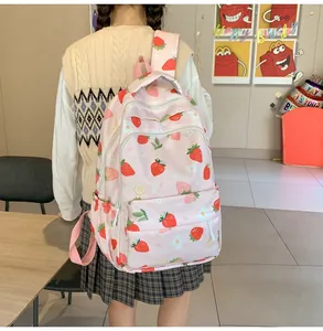 Detailed view of lightweight pink backpack with cute strawberry and daisy prints