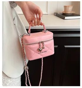 Detail of pink quilted leather bag with silver heart charm and chain strap