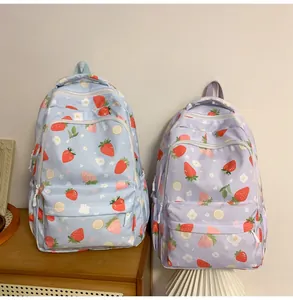 Detail showing blue and purple strawberry print backpacks with a front zipper pocket