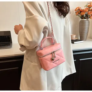 Detailed shot of pink quilted vanity bag with heart pendant and metal chain strap