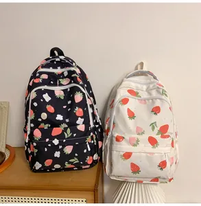 Front view of black and beige strawberry print backpacks on a wooden shelf