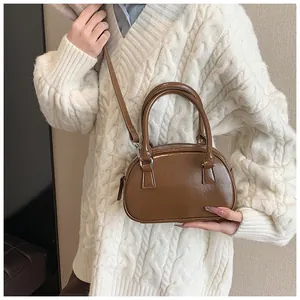 Détail du sac bowling marron brillant en simili cuir avec double poignée et bandoulière