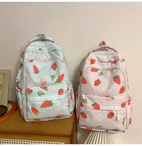 Detail showing high-capacity student backpacks with strawberry prints in blue and pink