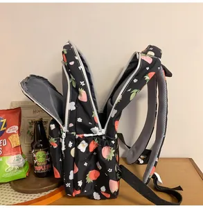 Detail view of the strawberry print backpack featuring multi-layer storage compartments