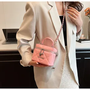 Detail of pink quilted leather vanity bag with gold-tone heart charm and chain strap