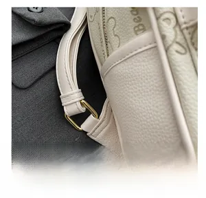 Detail des beige Lederrucksacks mit goldener Ringschnalle und geprägter Logotextur