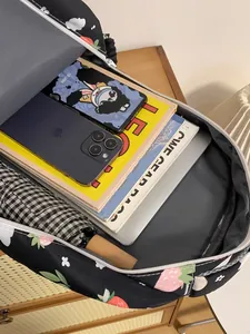 Large capacity black strawberry print backpack showing organized storage for laptop and books